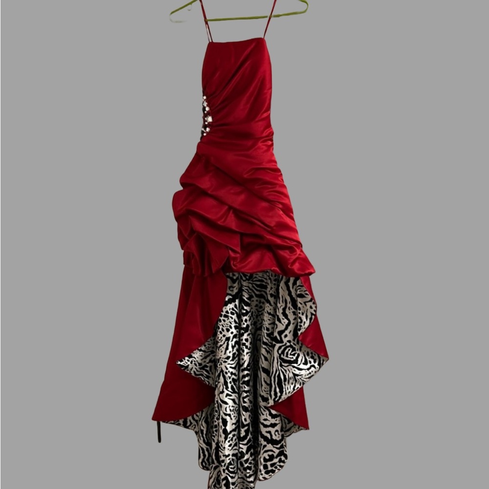 Woman’s red satin ruched evening gown with jewel detail long the side.